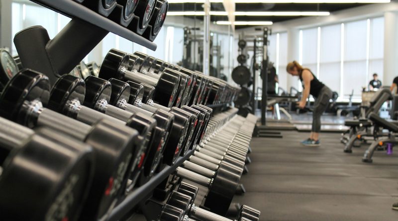 woman standing surrounded by exercise equipment